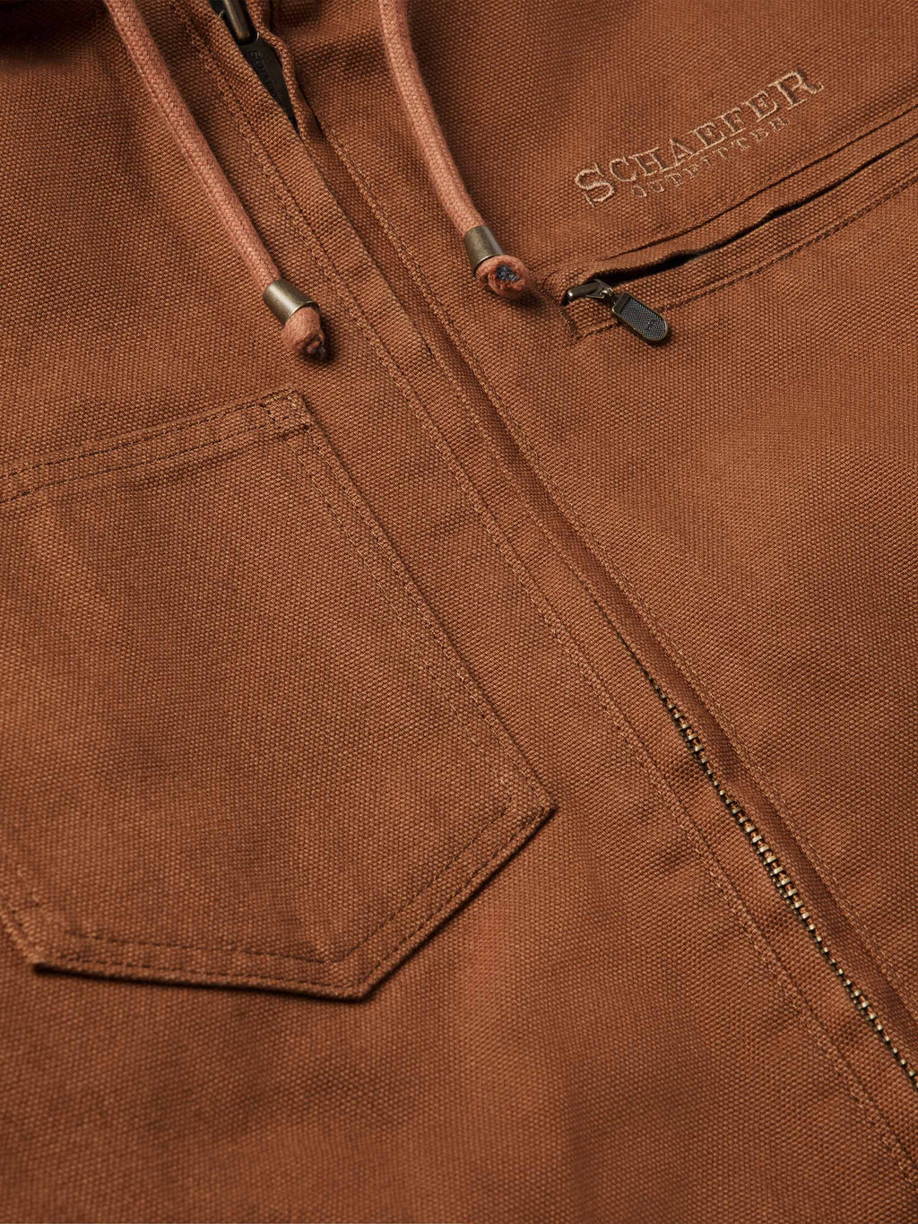 Russet canvas jacket close-up of front zipper and branded chest label