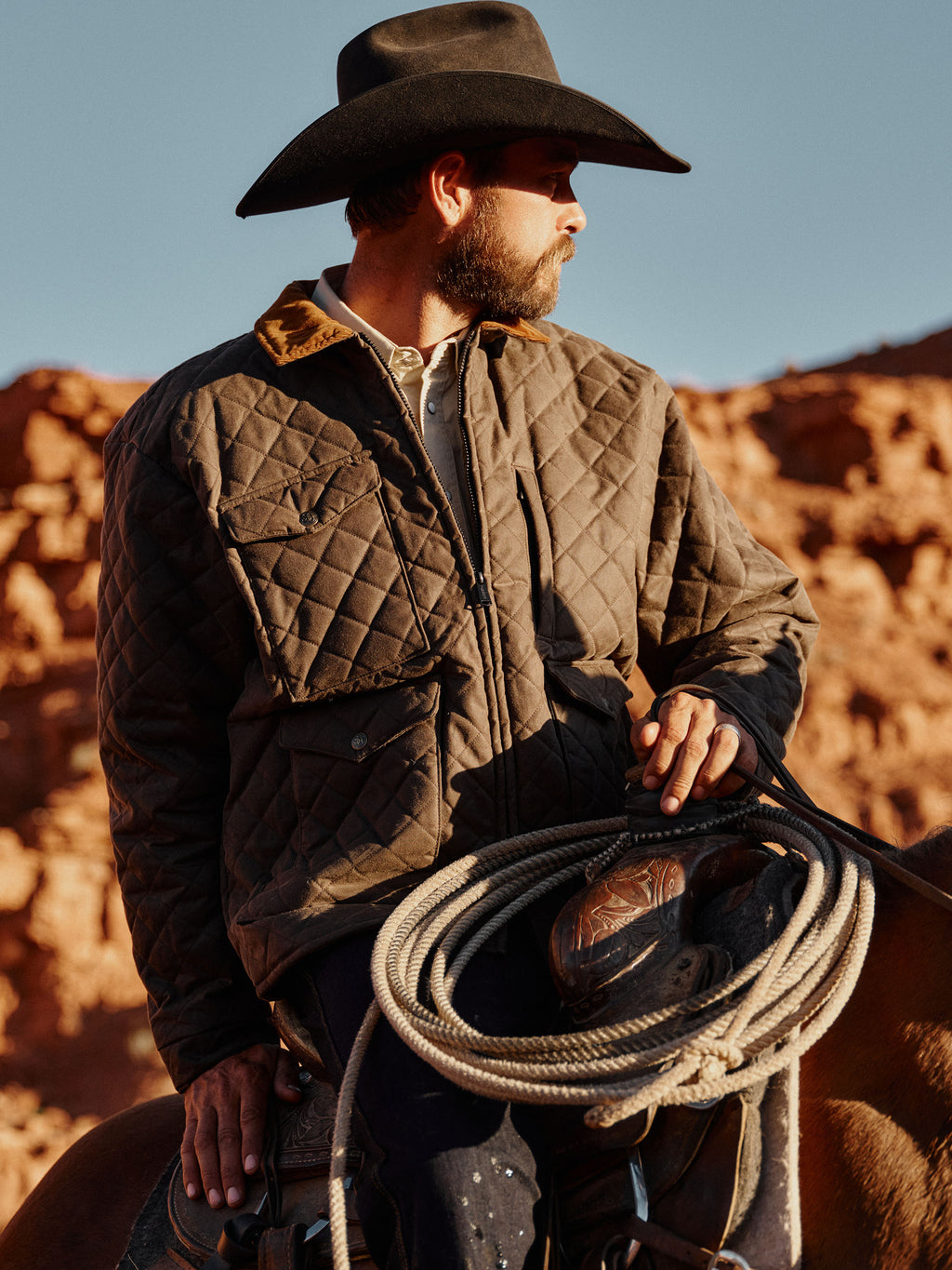 Dark brown quilted jacket worn by rider with diamond quilting and corduroy collar
