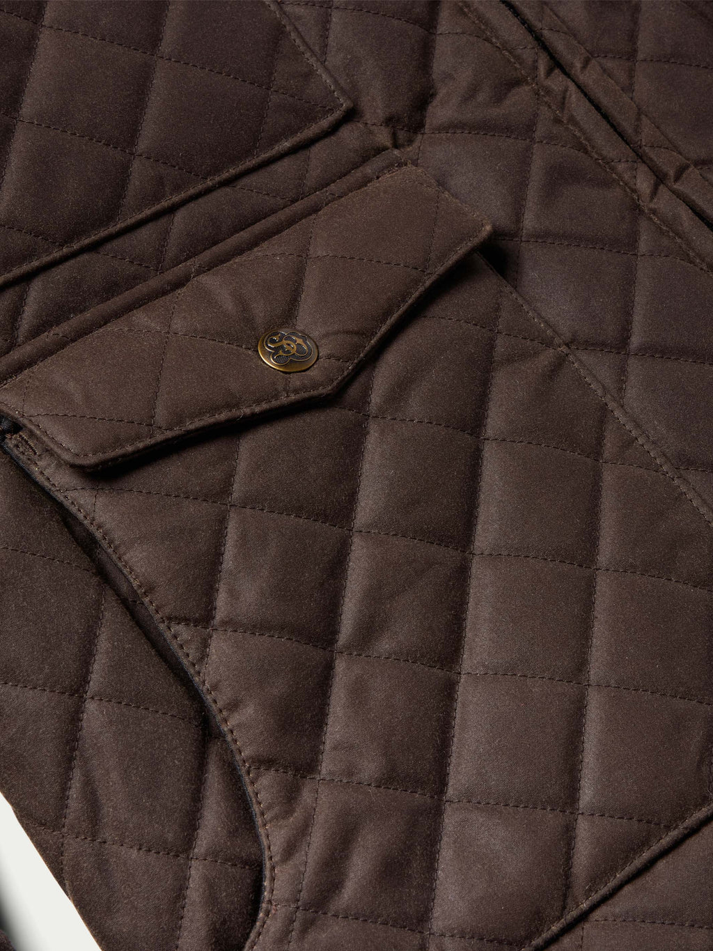 Dark brown quilted jacket close-up of snap placket and diamond stitching