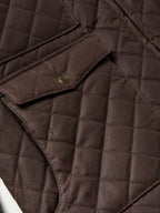 Dark brown quilted jacket close-up of snap placket and diamond stitching