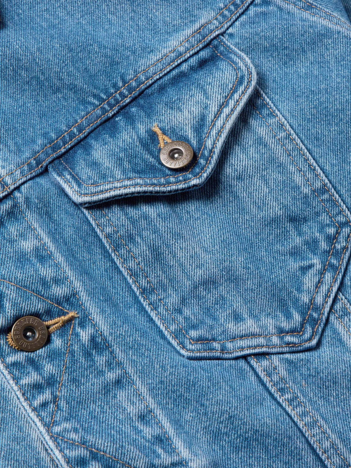 Medium indigo denim jacket close-up of snap buttons on shoulder and pocket