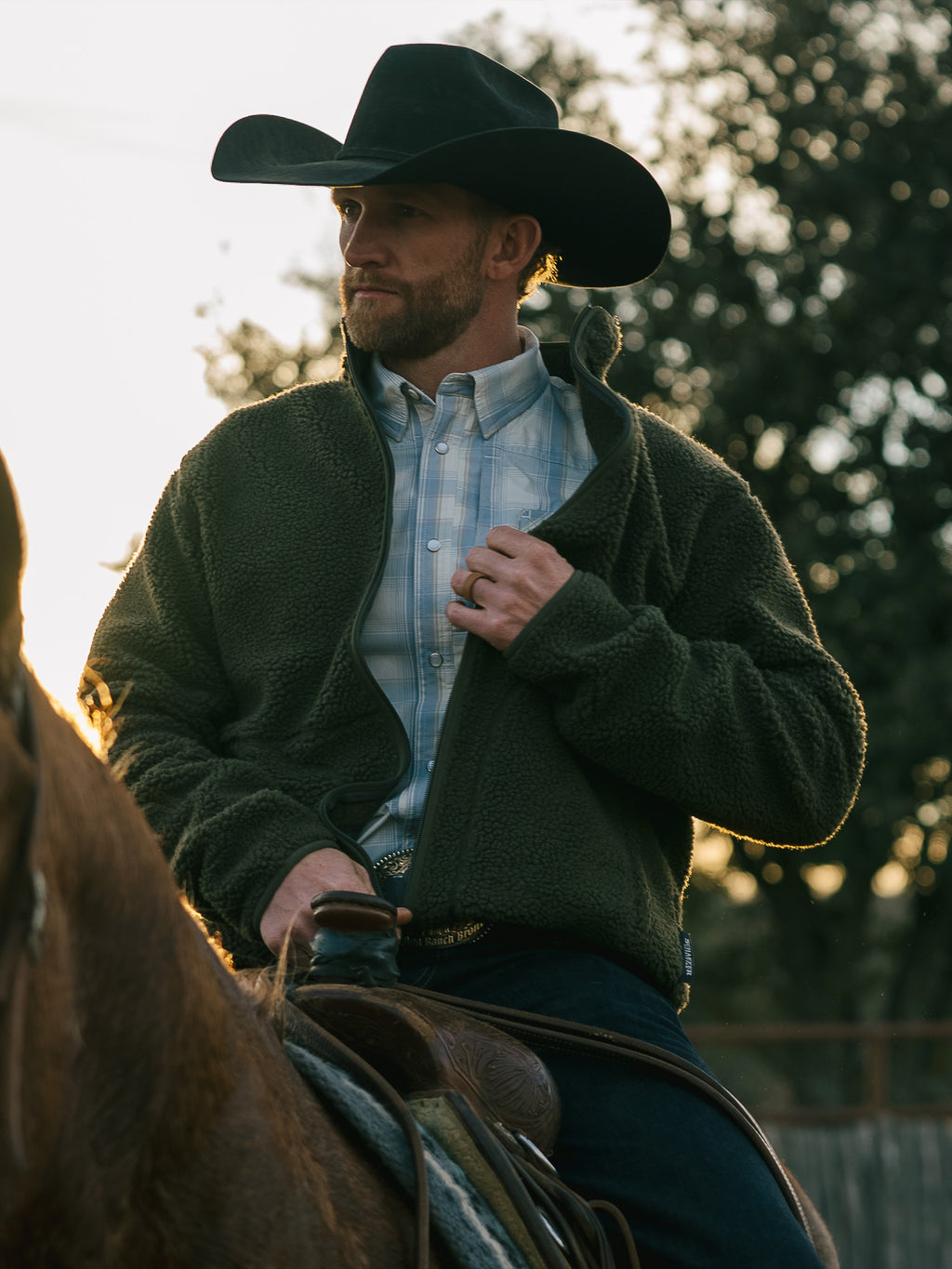 Olive full-zip fleece jacket on a man outdoors, zip front and thick fleece texture.