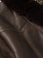 Leather coat shoulder and seam stitching detail in dark brown