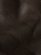 Close-up of dark brown pebbled leather texture and stitching