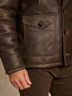 Dark brown shearling coat with square chest pocket and snap front detail