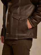 Men's dark brown shearling coat with flap chest pocket and snap closure details