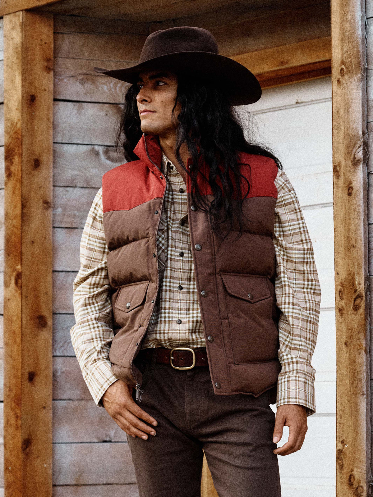 Bozeman down vest on model in maroon and brown with teal interior lining
