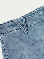 Medium wash denim jeans close-up of front rise and belt loop detail