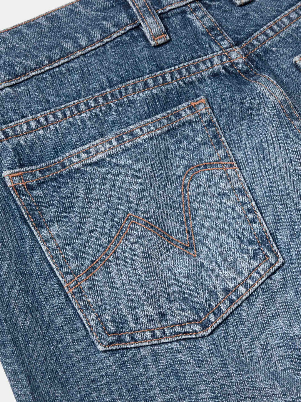 Medium-wash denim front pocket with stitched detail and orange topstitching.