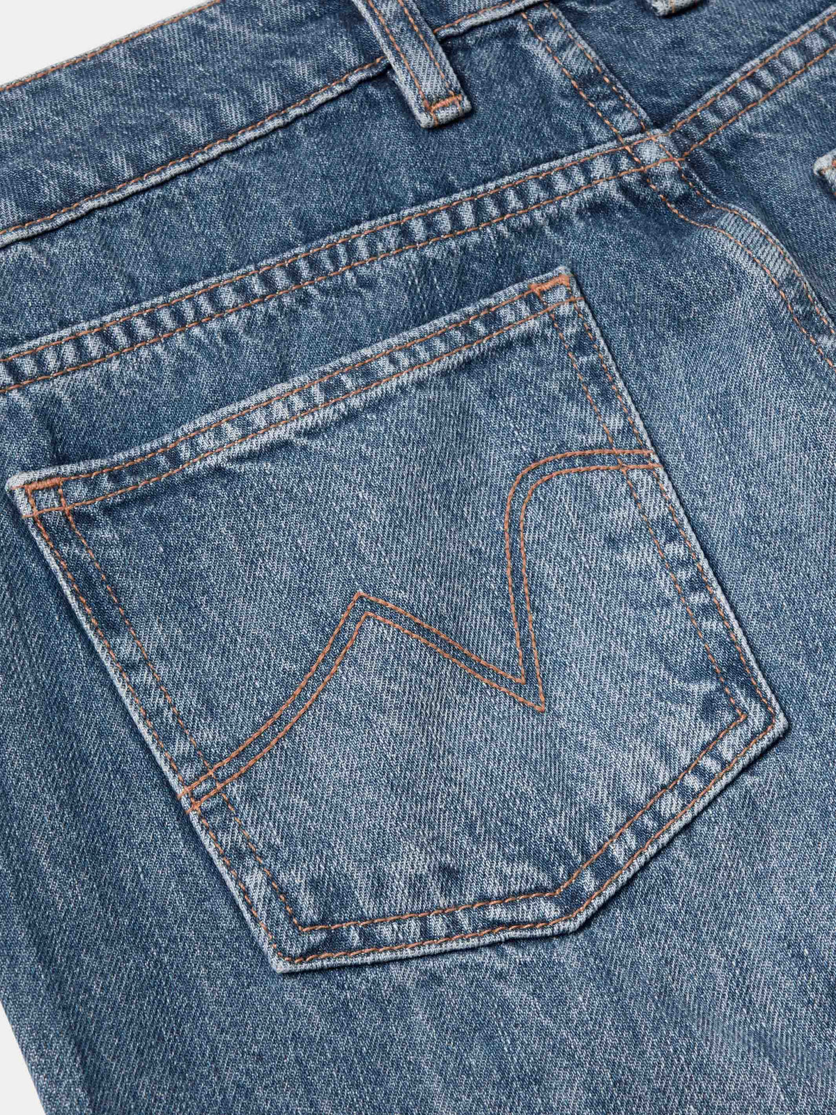 Medium-wash denim front pocket with stitched detail and orange topstitching.