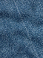 Medium-wash denim fabric close-up showing blue textured weave.