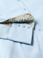 Light blue women's button-up shirt with patterned inner placket and button cuffs