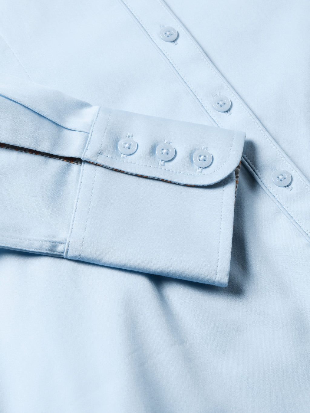 Light blue Reata button-up shirt cuff and lower placket seam with button details