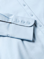 Light blue Reata button-up shirt cuff and lower placket seam with button details