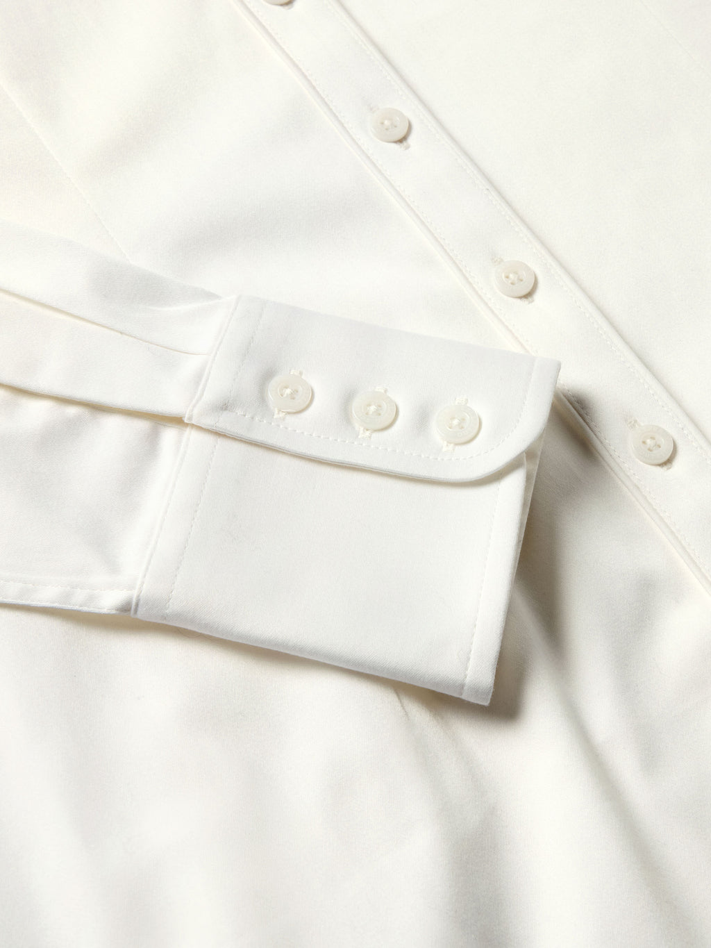White shirt cuff with single button and neatly stitched sleeve hem
