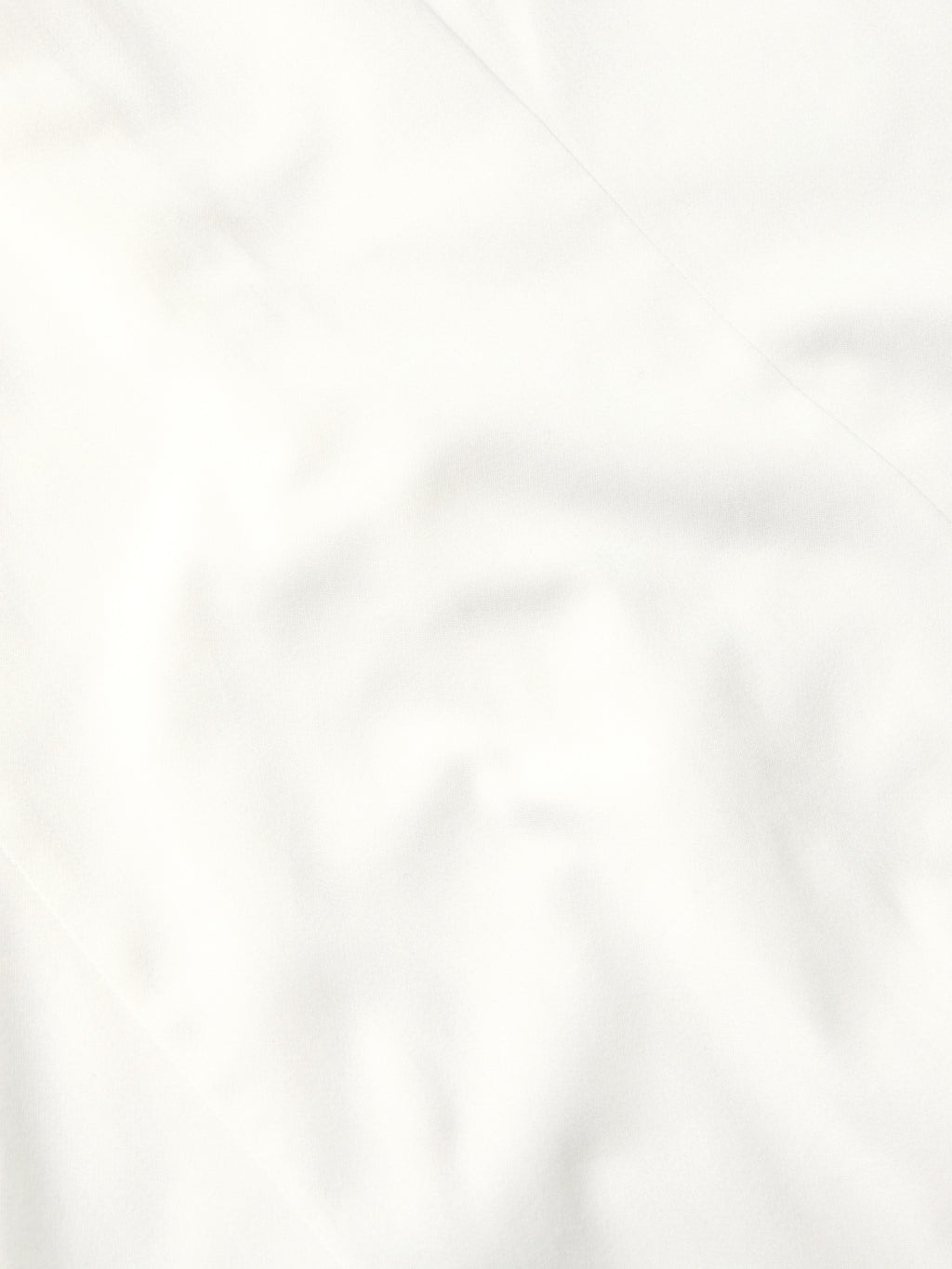 White shirt fabric close-up with smooth weave and subtle creasing