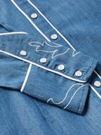 Chambray shirt cuff with white trim and embroidered snap/button details
