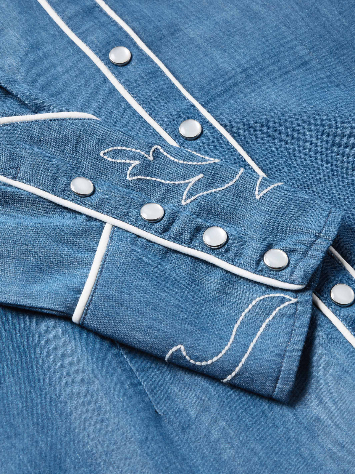 Chambray shirt cuff with white trim and embroidered snap/button details