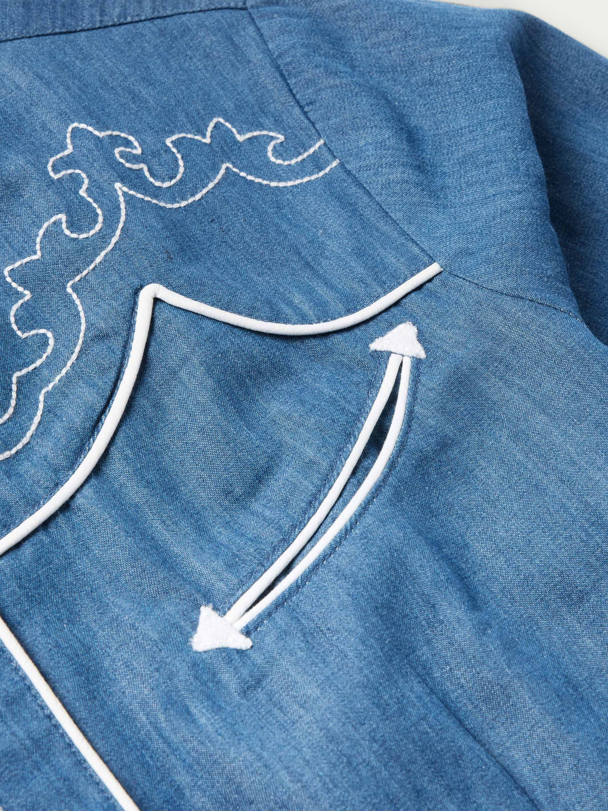 Chambray shirt shoulder yoke with white curved trim embroidery
