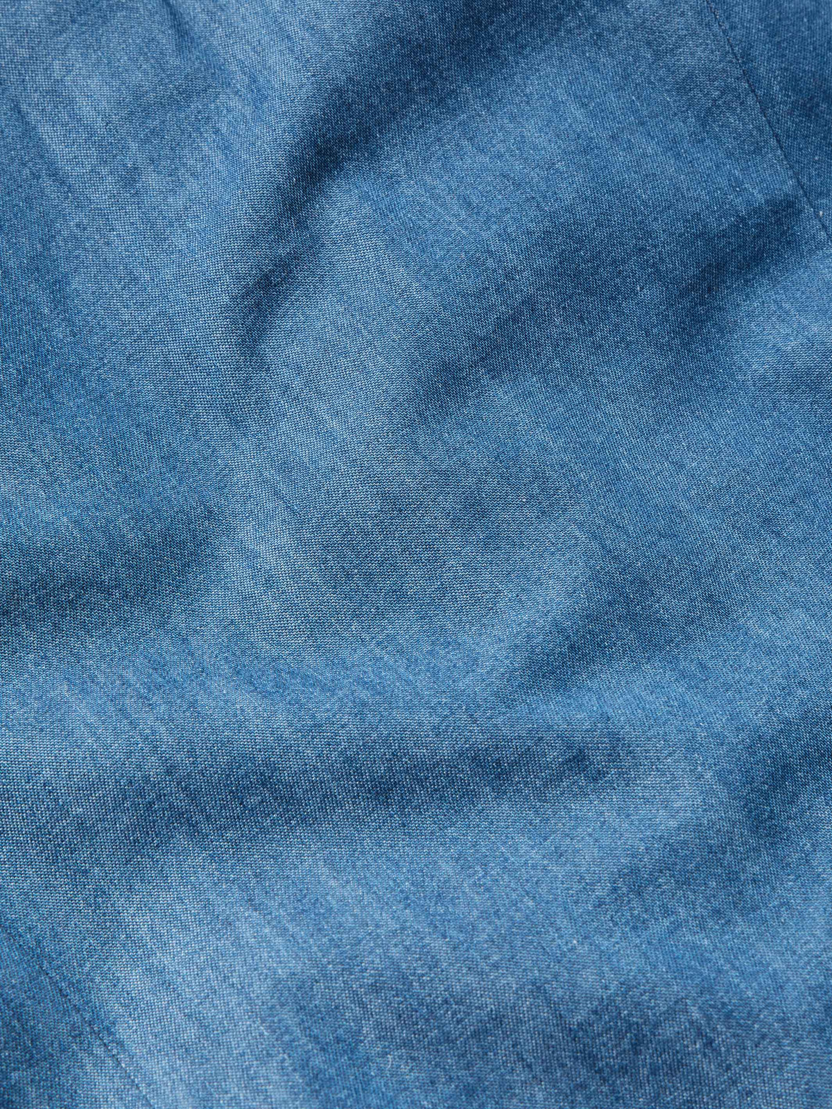 Chambray fabric texture swatch in blue with subtle woven grain