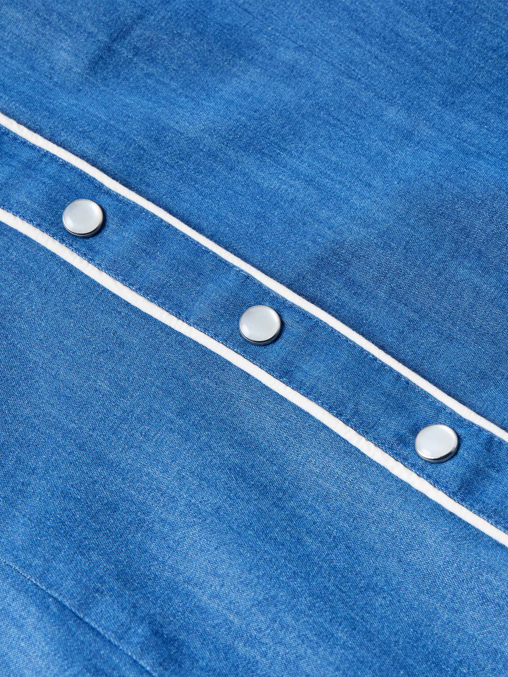 Chambray shirt sleeve cuff with white piping and round buttons