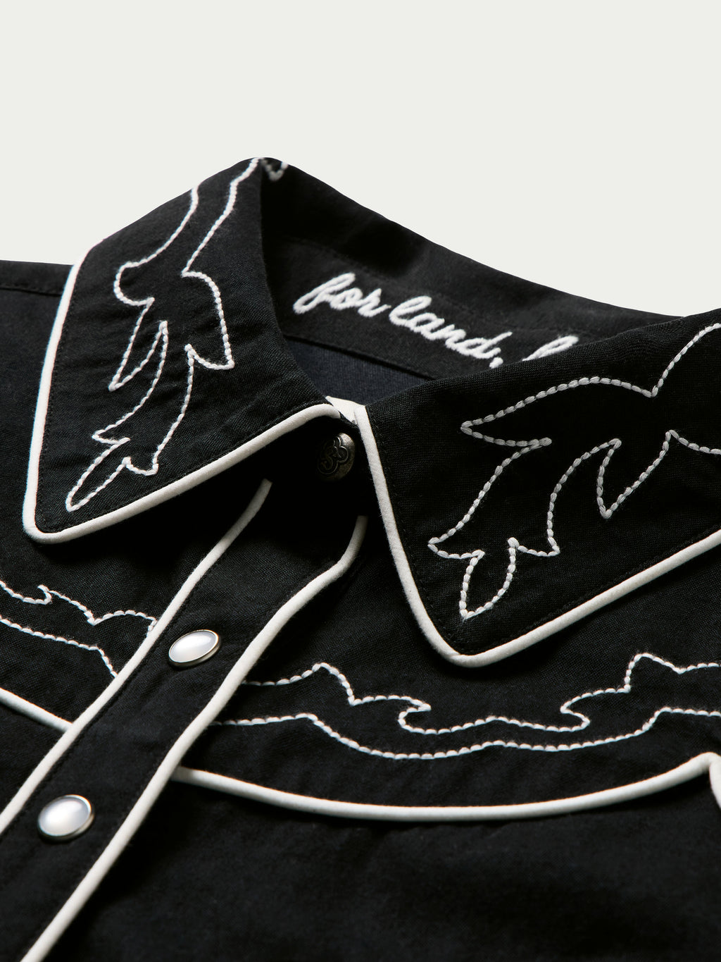 Women's embroidered Dale shirt with black fabric, white collar embroidery, and snap placket