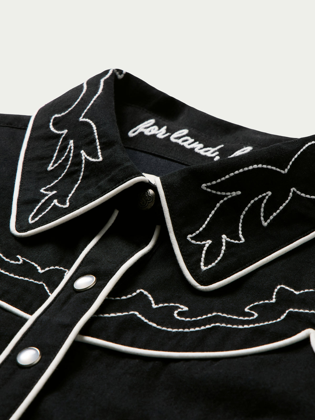 Women's embroidered Dale shirt with black fabric, white collar embroidery, and snap placket