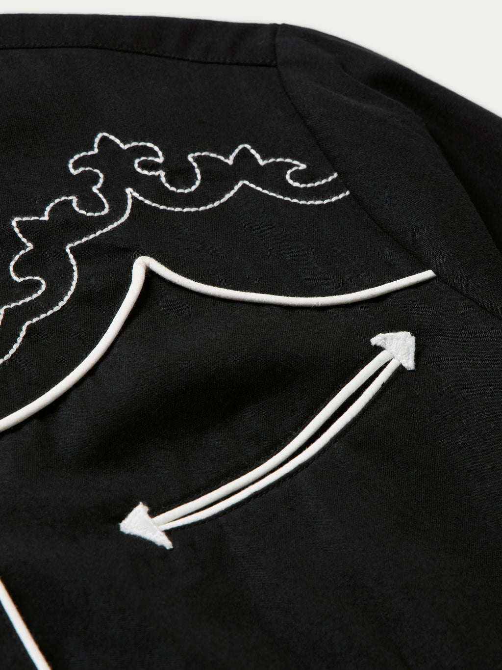 Women's embroidered Dale shirt close-up of white arrow embroidery on shoulder