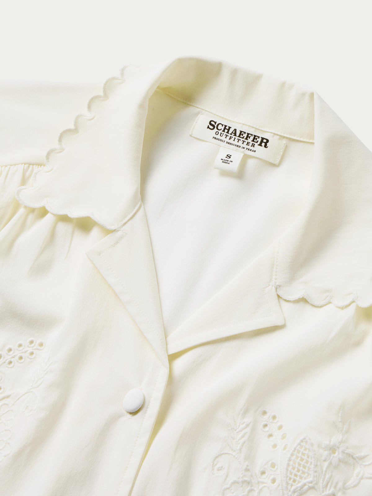 Vintage white blouse with scalloped collar trim, button placket, and embroidered accents