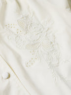 Vintage white blouse featuring dense floral and eyelet embroidery across the chest