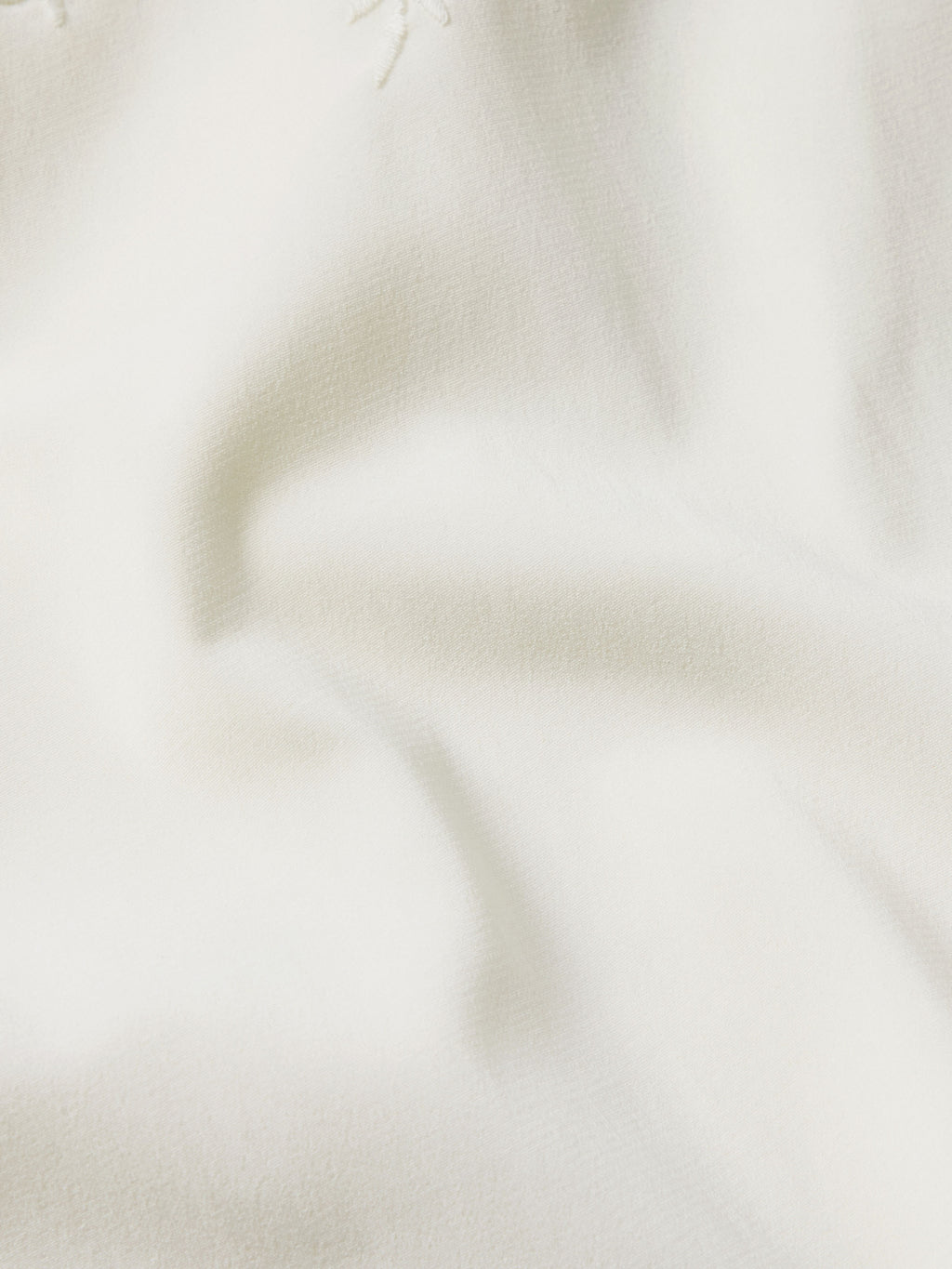 Close-up of vintage white embroidered fabric texture and fine eyelet stitching