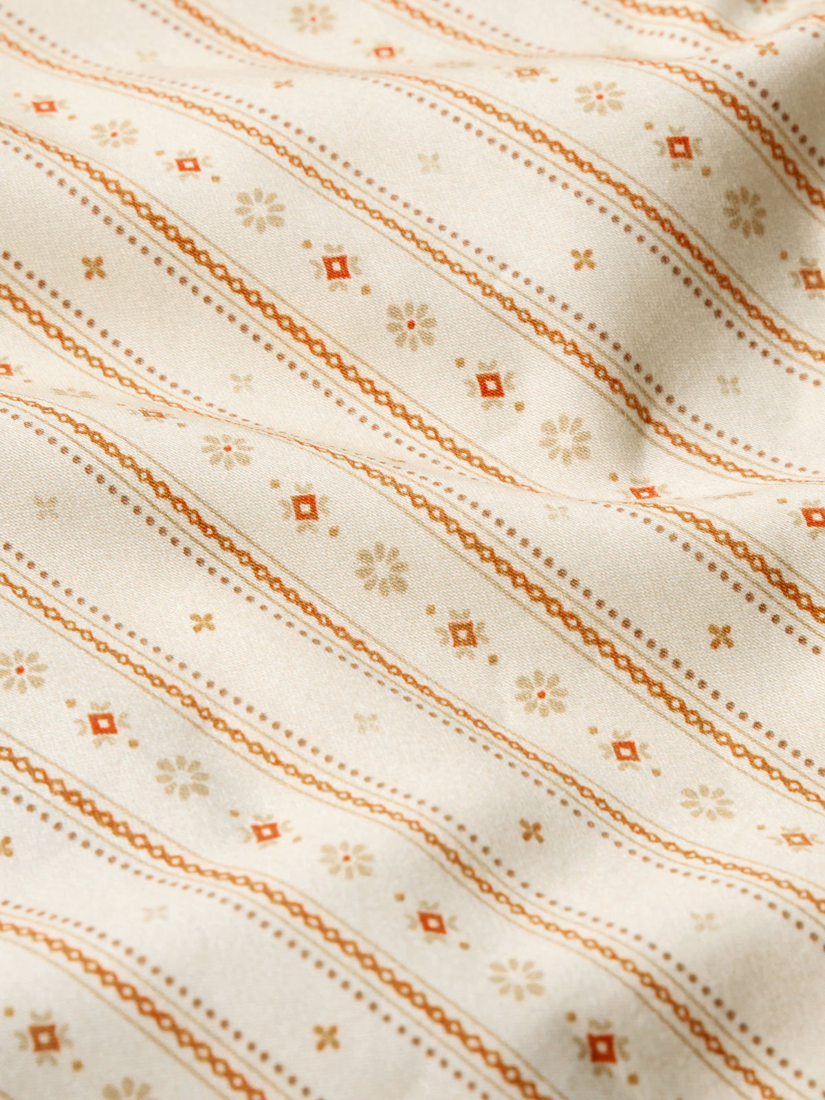Women's printed button-up shirt fabric close-up with orange and tan striped pattern