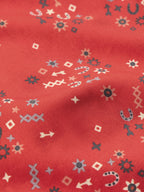 Red printed reata shirt fabric close-up with small icons pattern