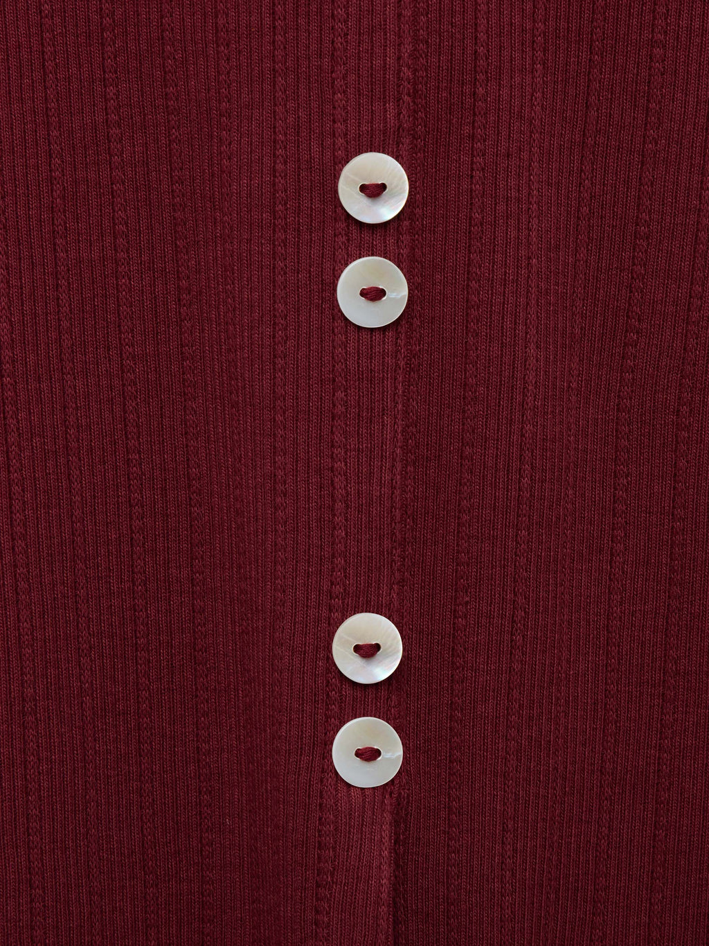 Wine ribbed knit fabric close-up with white button trim