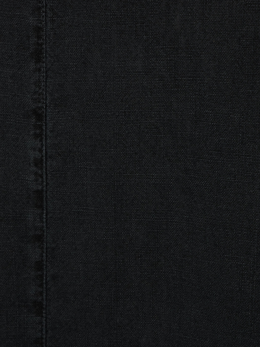 Washed black textured denim fabric with visible vertical seam