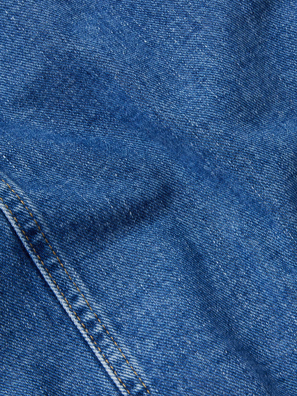 Indigo denim jacket fabric texture with stitched seams and paneling