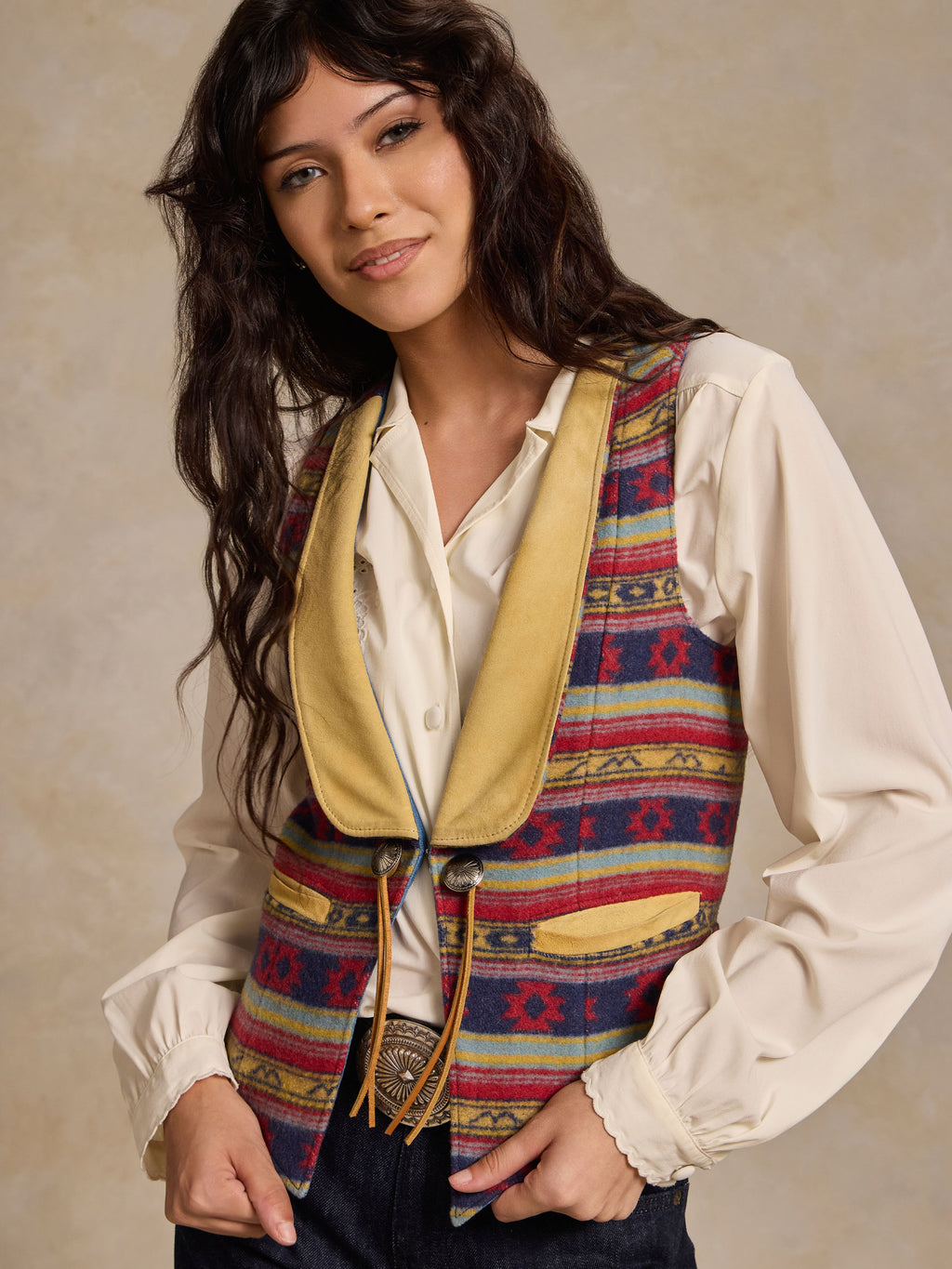 Wool vest with multicolor blanket stripe pattern, tan collar and decorative concho details
