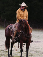 Suntan brush jacket on a cowboy next to a saddle horse