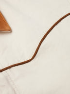 Natural coat neckline with brown cord trim and tan hood lining