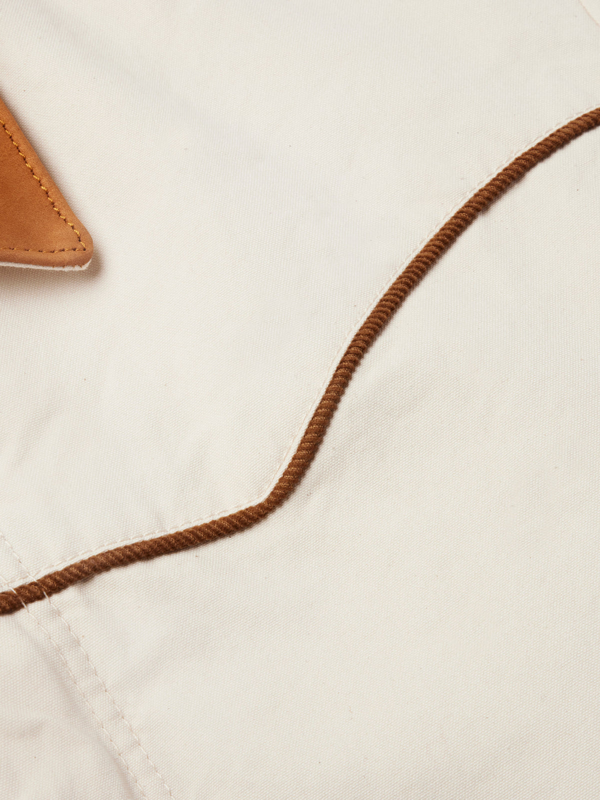 Natural coat neckline with brown cord trim and tan hood lining