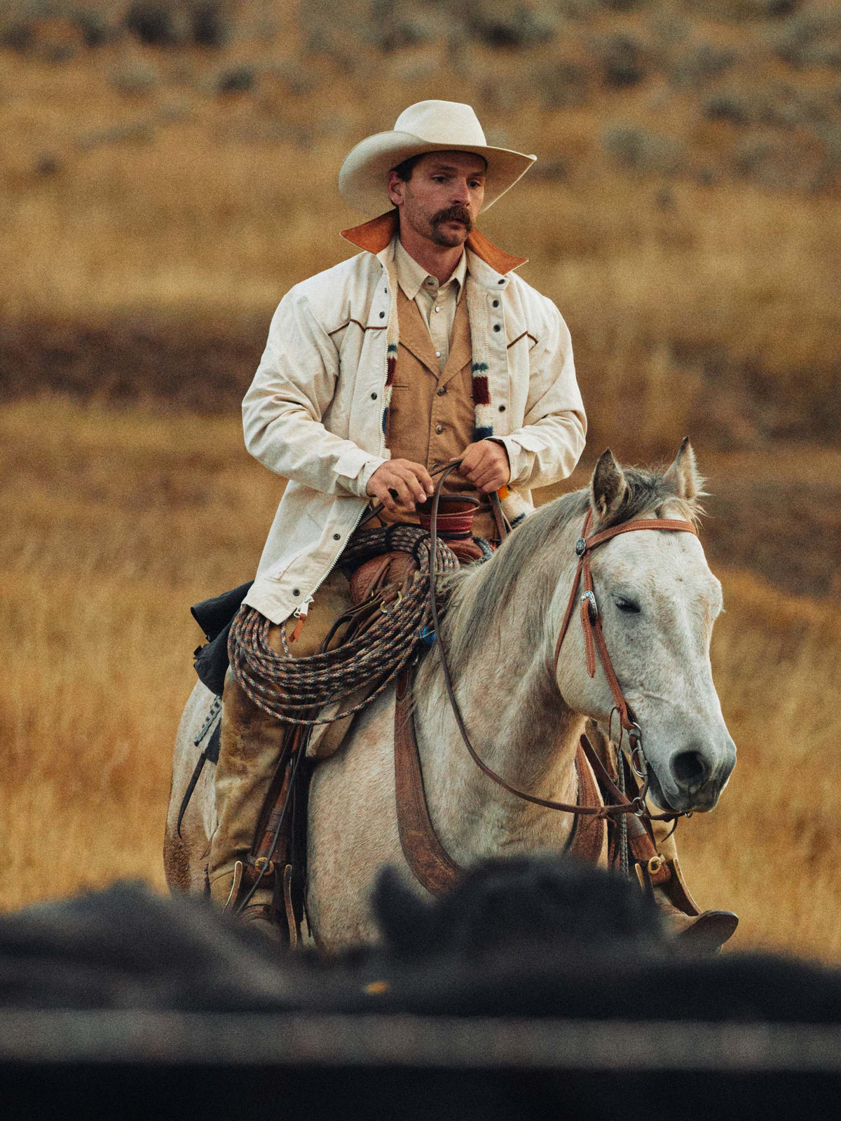 Natural drifter coat on horseback with multicolor striped yoke and white button front