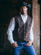 Men's chocolate-brown cowboy vest over a white shirt with blue jeans and hat