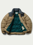 Camel and dark navy puffer down jacket with visible interior lining and tag