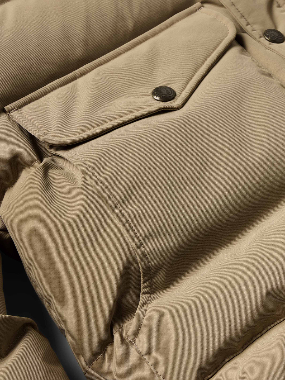 Camel jacket sleeve cuff and flap pocket detail with dark buttons