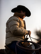 Tan and cream puffer down jacket in profile with high collar and insulated hood
