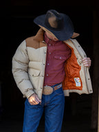 Tan and cream down jacket with snap front and two chest flap pockets