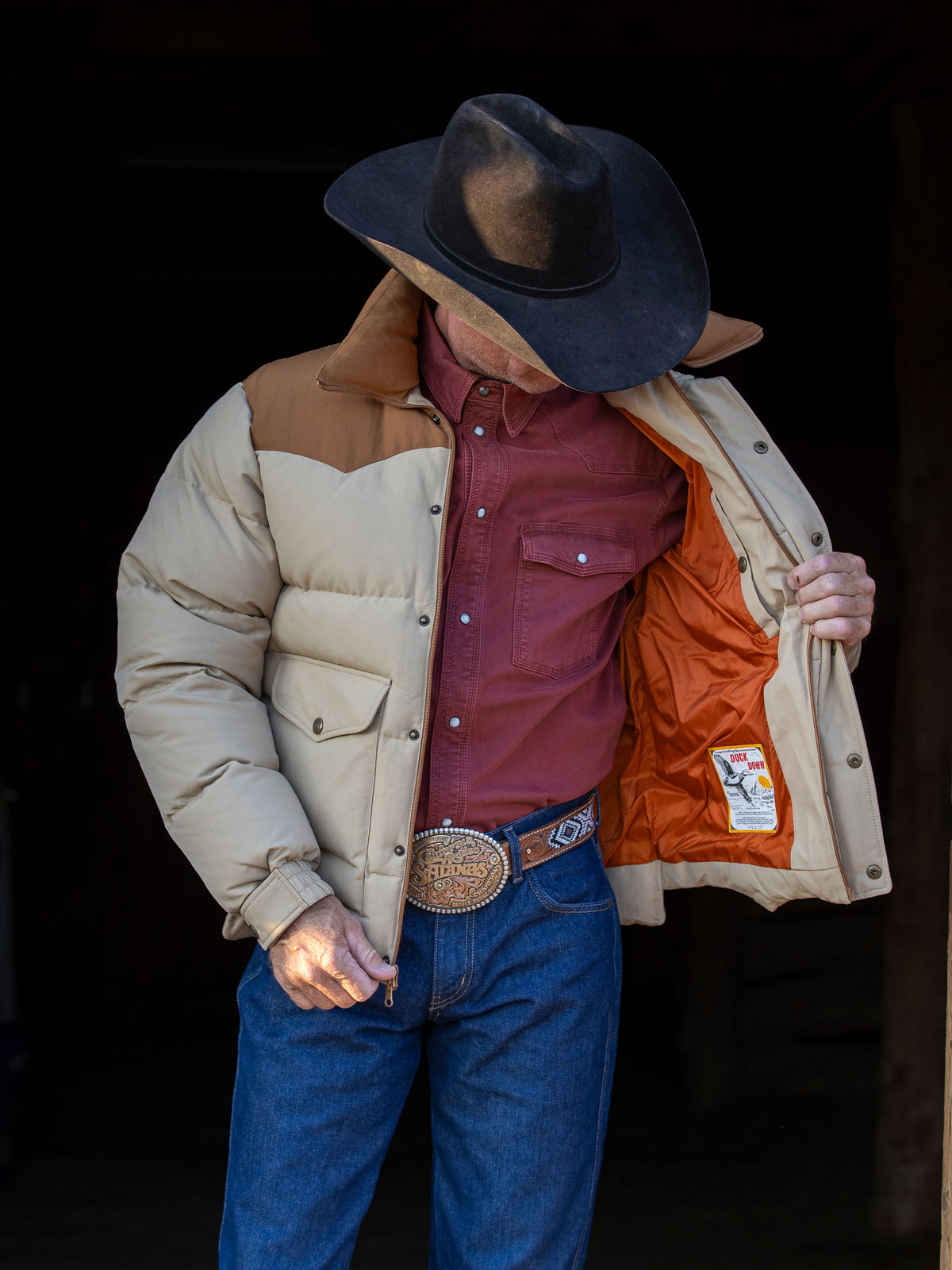 Tan and cream down jacket with snap front and two chest flap pockets