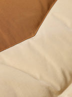 Tan down jacket with two-tone fabric panel and stitched seam
