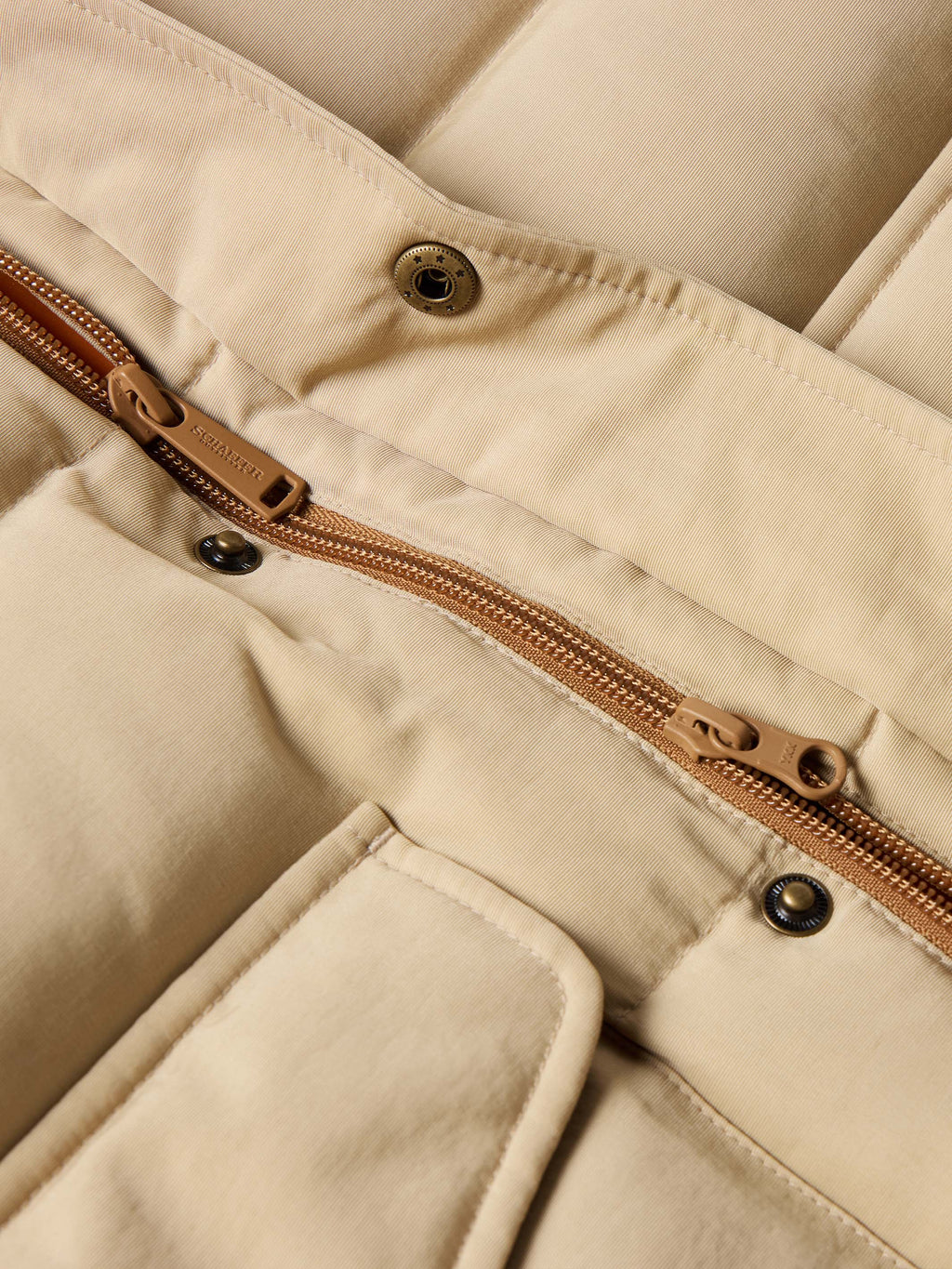 Tan down jacket zipper with bronze pull and snap-button flap