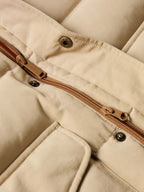 Tan down jacket zipper with bronze pull and snap-button flap